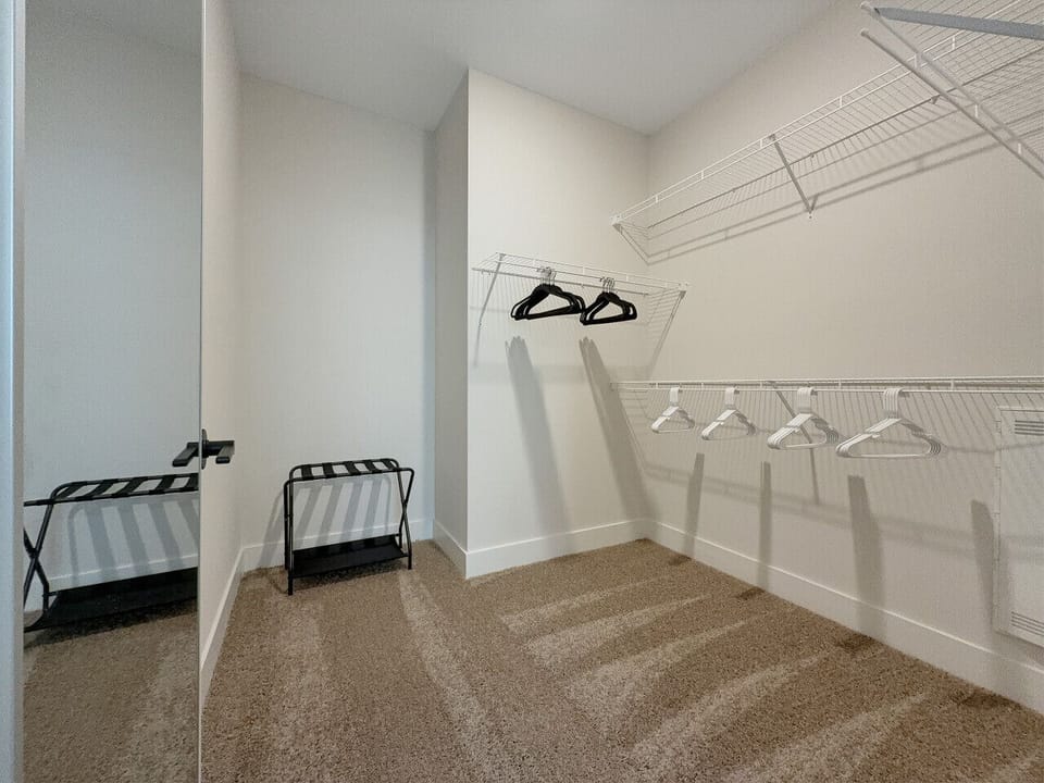 Master Walk-In Closet with Hangers and luggage racks