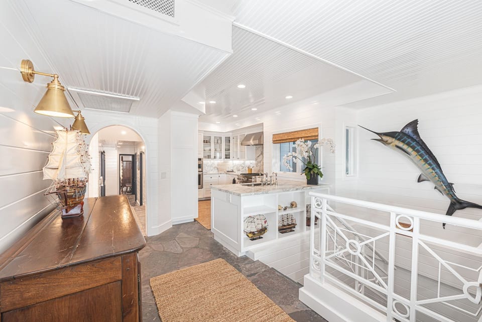 Bright upper hallway featuring nautical details and open layout leading to the second kitchen
                