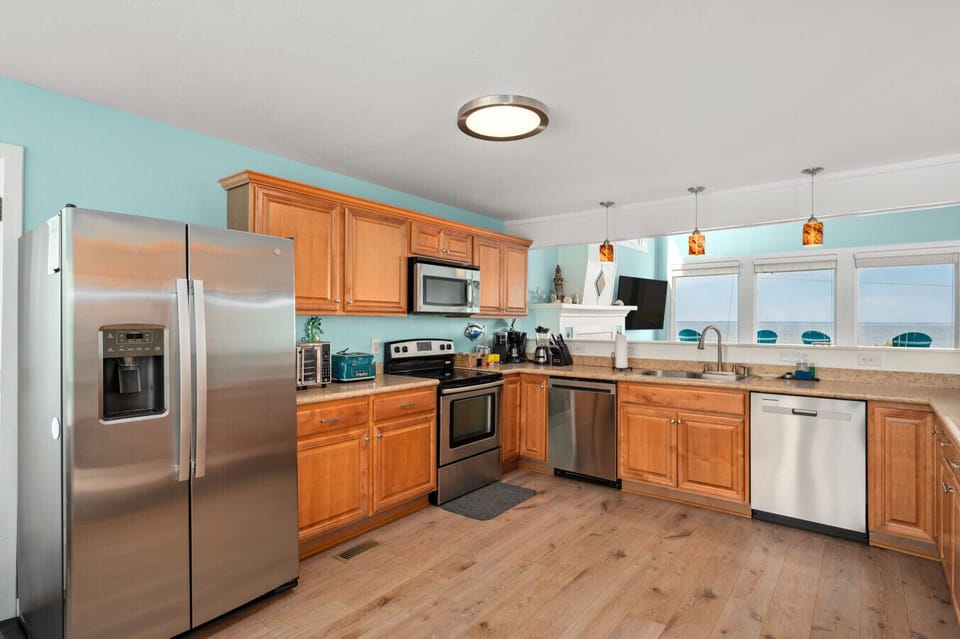 Open kitchen & dining area w/ warm wood cabinets & easy flow for shared meals.