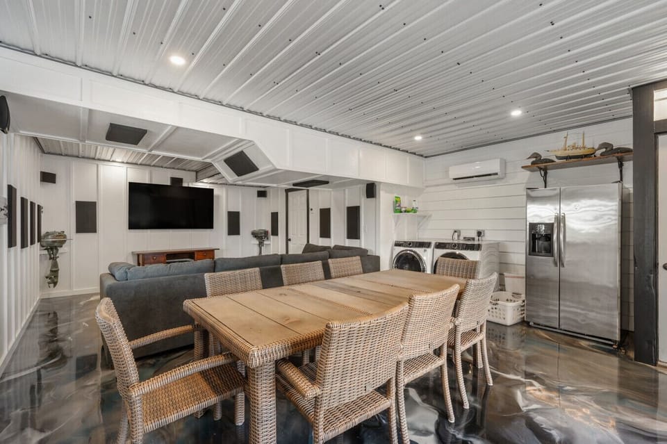 Converted garage turned entertainment room featuring a TV, surround sound system, its own mini-split A/C unit, and a fridge—perfect for relaxing and unwinding.