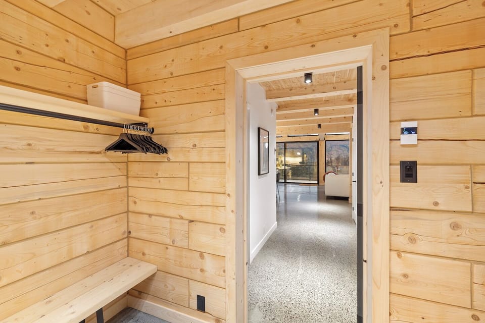 Spacious entrance hall with benches, hooks, shelf and clothes rail.