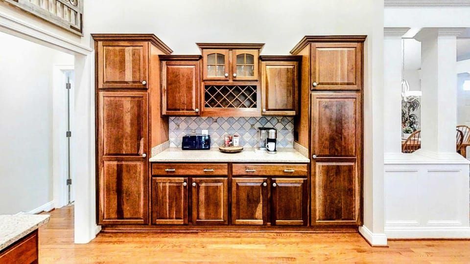 Beautifully built-in beverage station with ample cabinetry, granite countertops, and a convenient coffee maker—perfect for easy mornings and relaxed evenings.