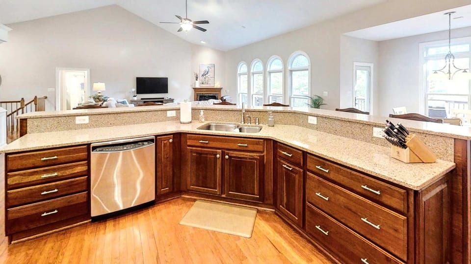 This open-concept kitchen offers expansive granite countertops, a built-in dishwasher, and clear sightlines to the living room—perfect for staying connected while prepping meals.
