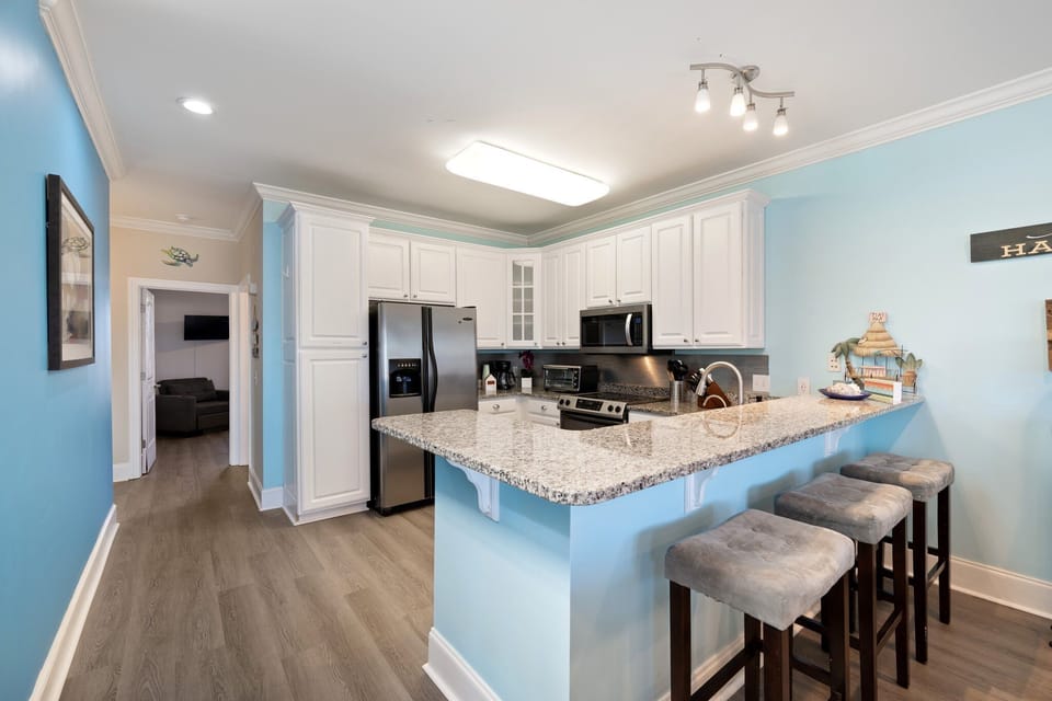 Your spacious kitchen features granite countertops, stainless steel appliances, and a breakfast bar perfect for morning coffee.