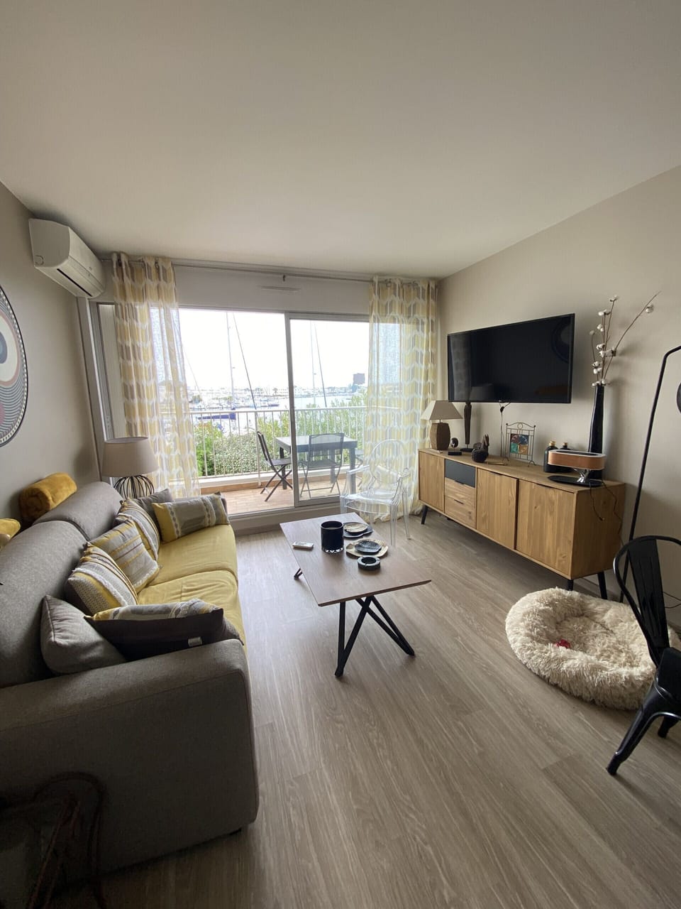 Modern and bright living room with sitting area, bay windows offering a breathtaking view of the port of Port Camargue, and all the amenities needed for a pleasant stay