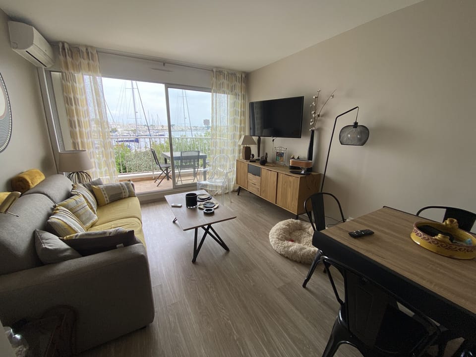 Bright and spacious living room, benefiting from floor-to-ceiling windows, with a sitting area and a dining area