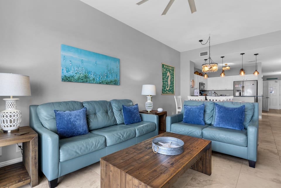 Living Room - Kick back in this bright living room with a comfy sofa and love seat, and a large comfy chair—ample seating for family and friends, with a queen sleeper sofa.