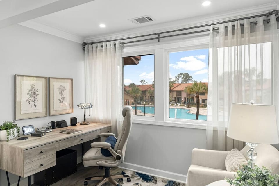 Workspace in the primary bedroom that greets you with a relaxing pool view while checking items off your to-do list