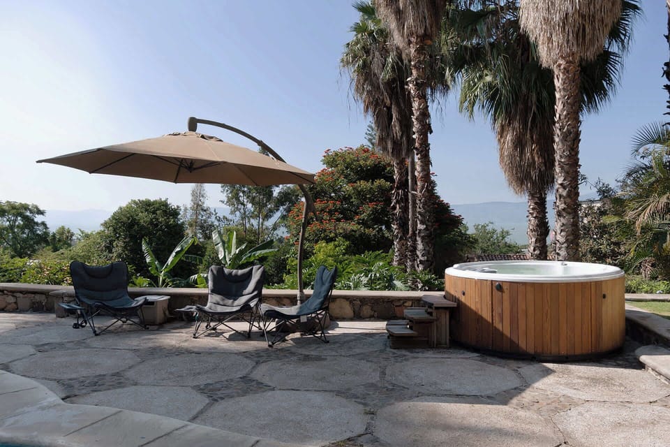 Jacuzzi | Soak in the outdoor whirlpool with stunning lake and hillside views