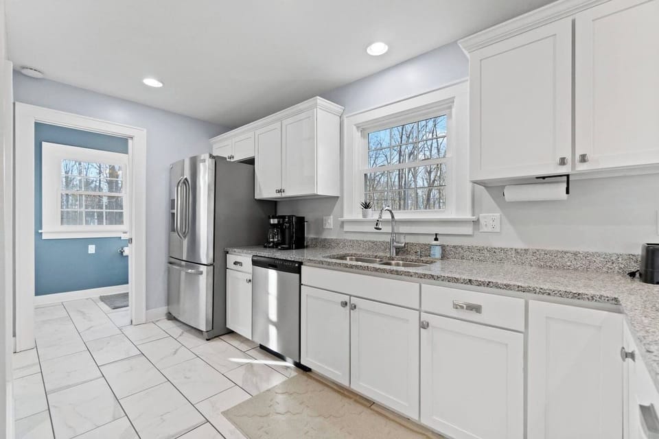 Brew your morning fuel exactly how you like it. This fully equipped white kitchen leads right to a handy half bath and features ample counter space for packing picnic snacks.
