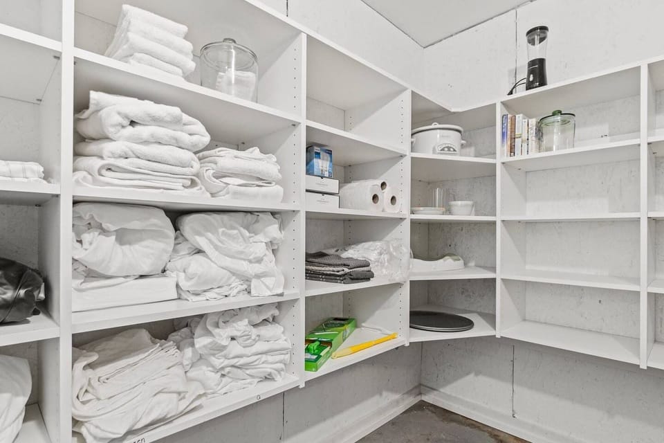 Never run out of space during week-long stays with this massive walk-in pantry stocked with extra fresh linens, towels, and backup kitchen essentials.