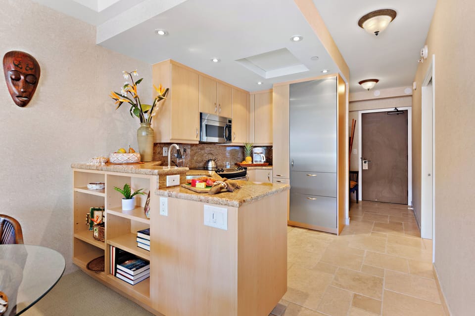 Contemporary kitchen with rich wood cabinetry, refined finishes, and a spacious island designed for effortless dining and entertaining in a relaxed coastal setting