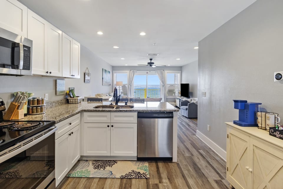 Fully stocked kitchen with view to living room and ocean