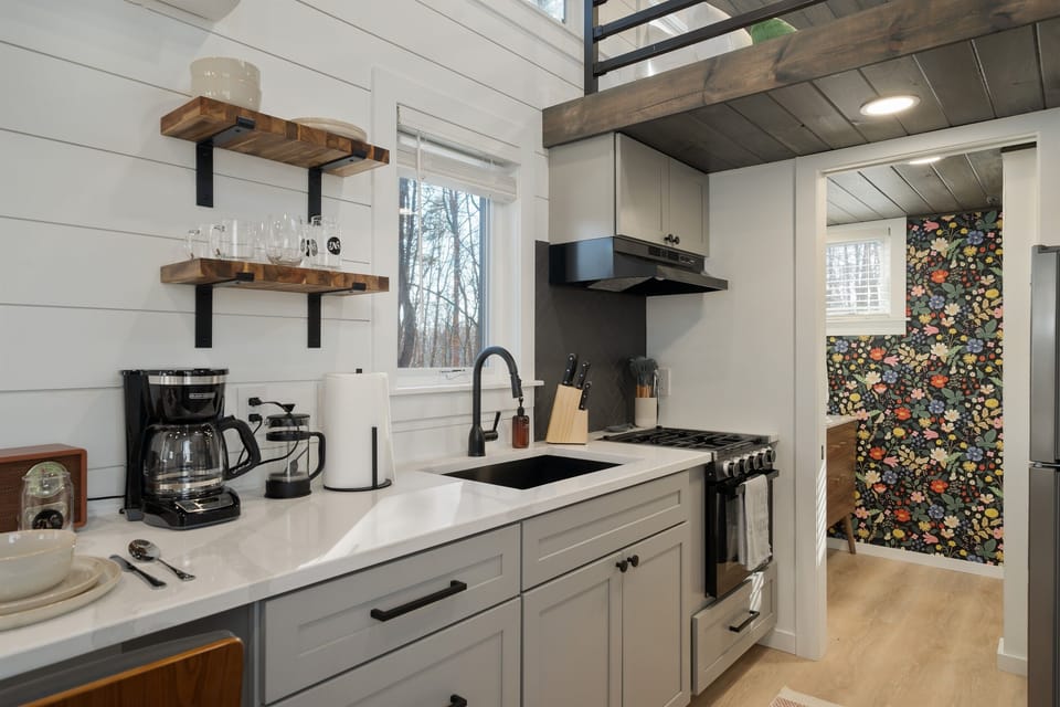 Kitchenette at Yeats — coffee maker, sink, stovetop, botanical wallpaper detail, pantry basics stocked on arrival