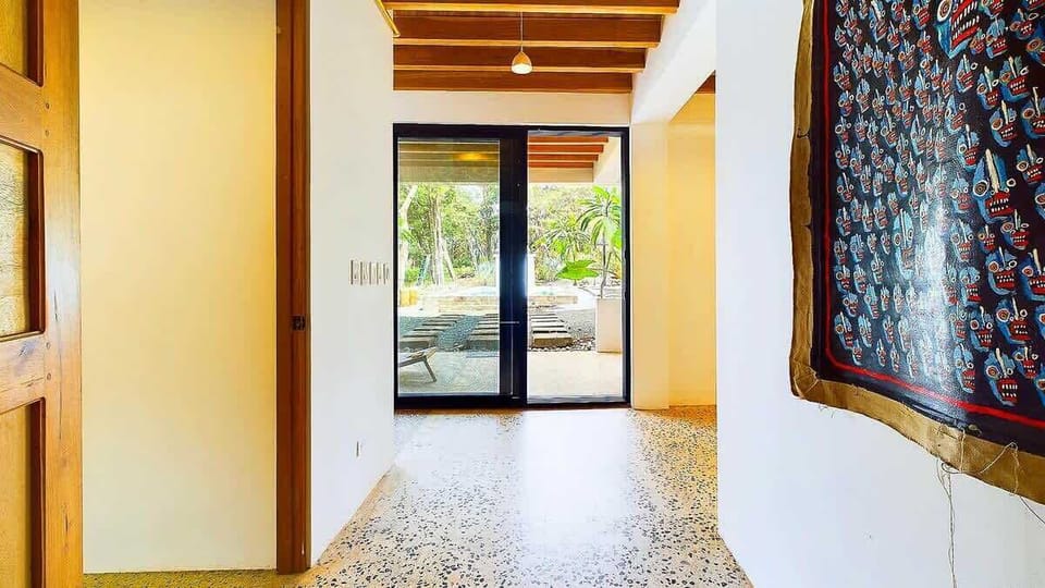 The ground floor features a bedroom, a full bathroom, and a fully equipped outdoor kitchen and bar overlooking the private pool.