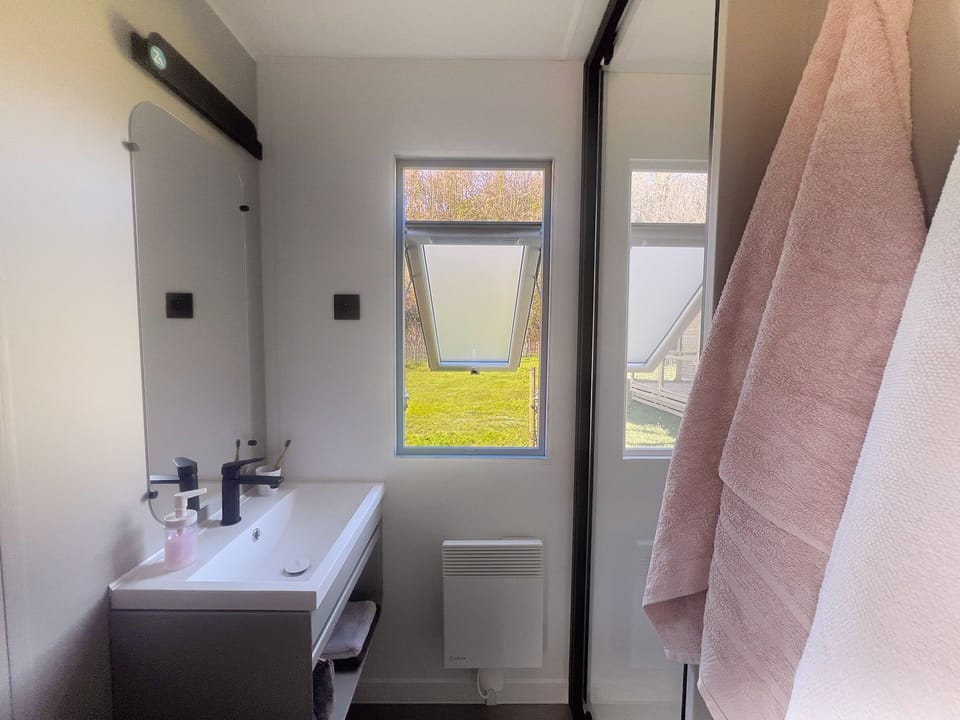 This thoughtfully designed bathroom offers both style and practicality, ensuring a comfortable experience with natural light and ample storage.
