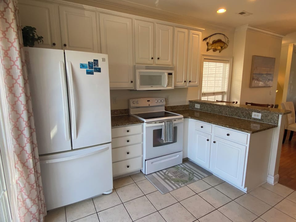 Bright kitchen with full appliances and ample cabinet space.