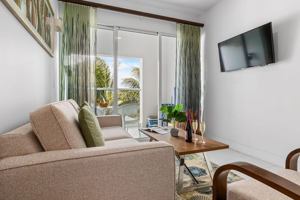 Balcony access living room with smart tv, and sofa bed