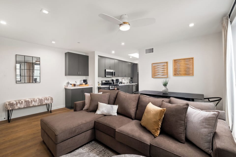 Spacious living room with cozy seating, large windows and a smart TV.