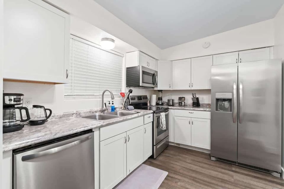 Modern, fully equipped kitchen featuring stainless steel appliances, coffee maker, and all the essentials, perfect for home-cooked meals during your stay.