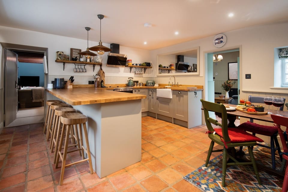 Wrays Cottage - the open-plan kitchen with a breakfast bar and table