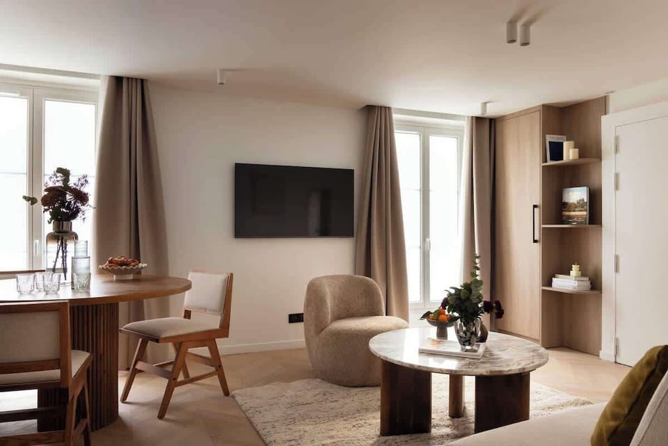 Une belle pièce à vivre dotée d'un canapé convertible, une table d'appoint, une table à manger et une TV.  