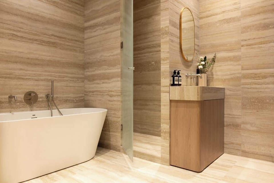 Une première salle d'eau avec baignoire, douche à l'italienne, et WC