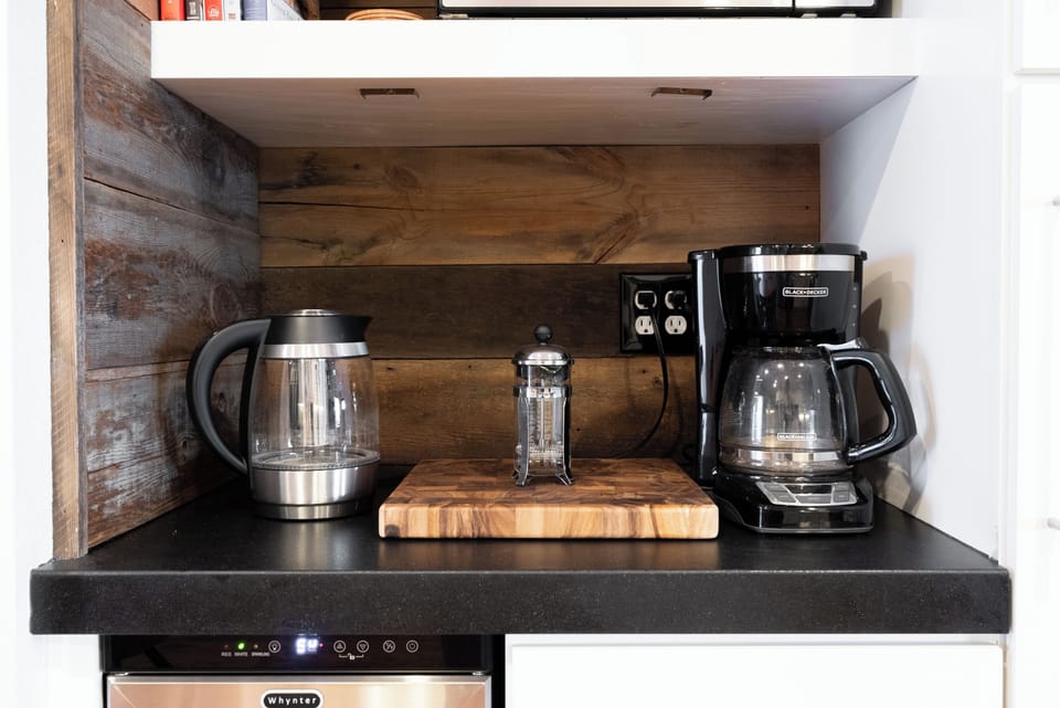 Start your morning at this charming coffee station, complete with a French press, electric kettle, and drip brewer.