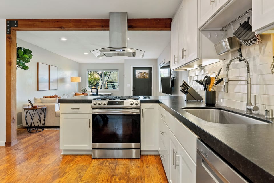 Prepare meals with ease in this bright, functional kitchen featuring a professional-grade faucet and a modern gas range.