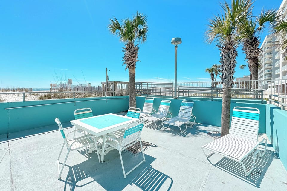Tables and loungers at pool Westwind Condo in Gulf Shores, AL.