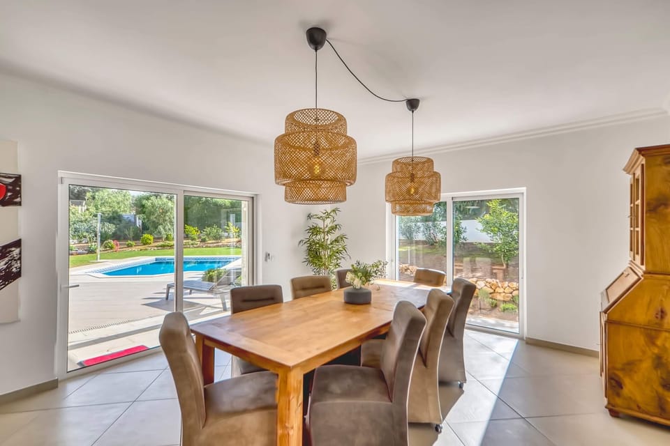 Large and bright dining area with large dining table for 8 people overlooking the pool and garden