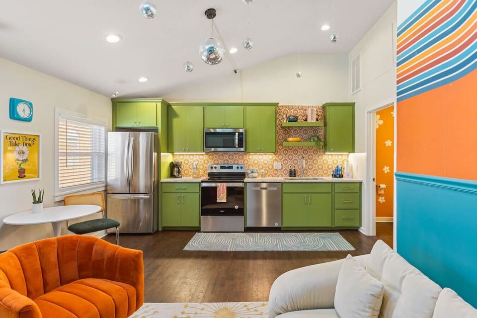 Fully equipped kitchen with all your cooking essentials, drip coffee maker + coffee. Dining table with seating for 2. This room opens up into the living room. Bold colors, bright lights and decor all throughout the condo.