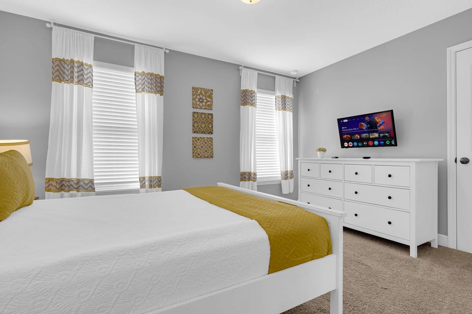 Bedroom 3 features a queen-size bed, flatscreen TV, closet. En-suite bathroom shared with Bedroom 4 contains shower over bath, sink, WC.