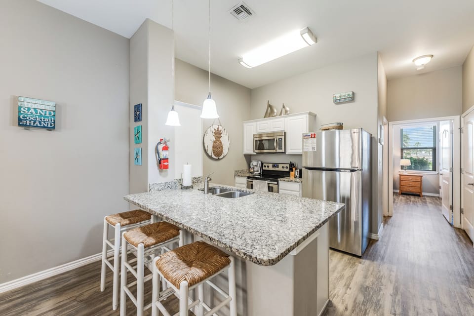 Cook up your perfect beach getaway in this fully-equipped kitchen with granite countertops, stainless steel appliances, and a breakfast bar for casual dining.