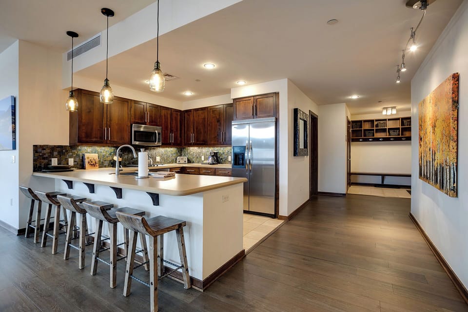 Your spacious kitchen features rich wood cabinets, modern appliances, and a large island with bar seating perfect for cooking and entertaining.