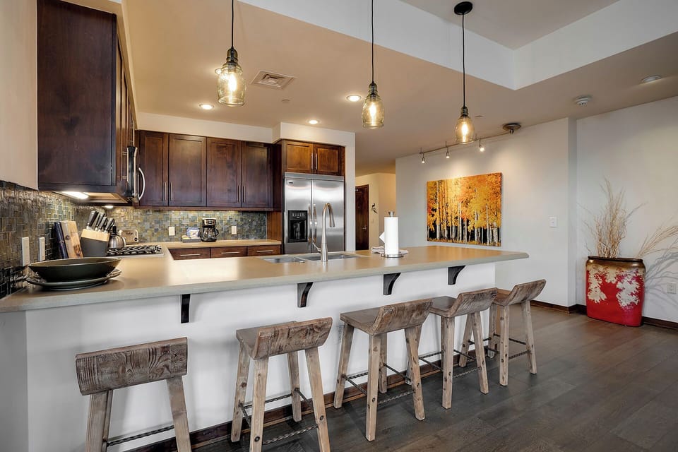 Gather around your spacious kitchen island with rustic bar seating, where pendant lighting creates the perfect ambiance for cooking and conversation.
