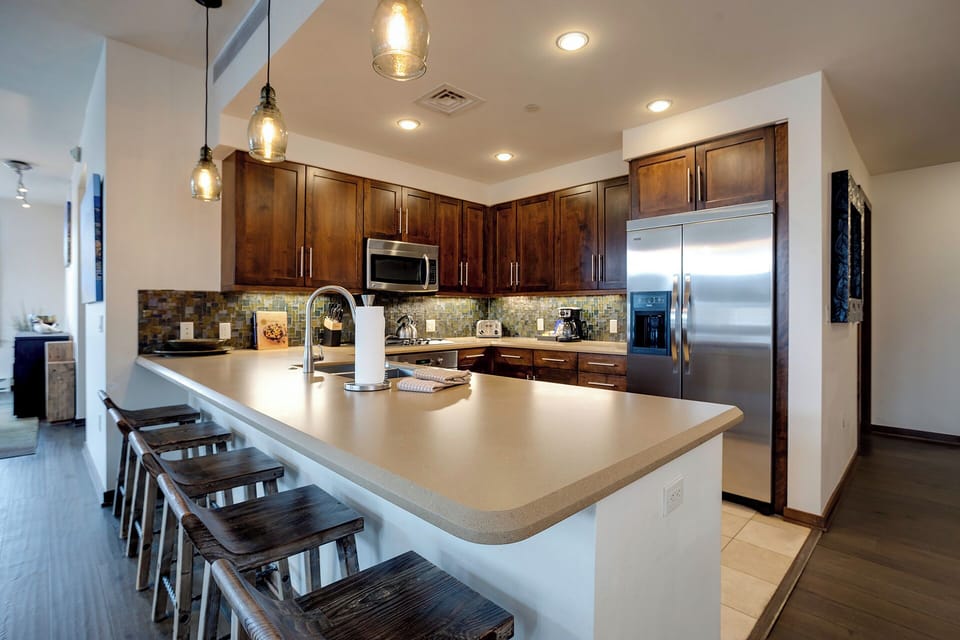 Your gourmet kitchen features rich wood cabinetry, stainless steel appliances, and a spacious island perfect for meal prep or casual dining.