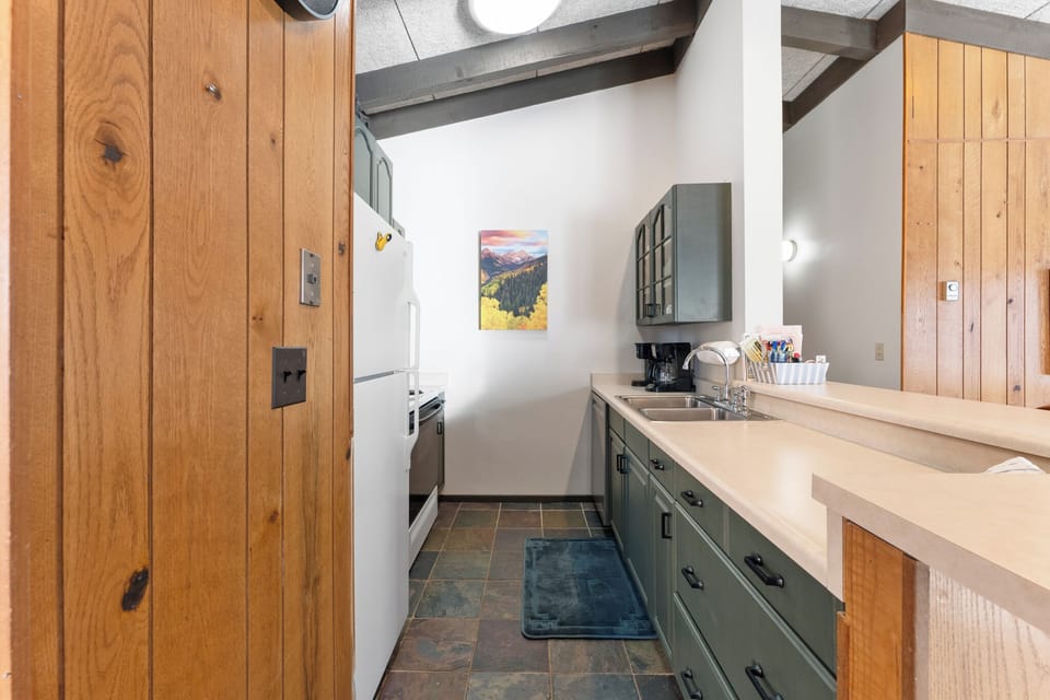 Your fully equipped kitchen features green cabinetry, warm wood accents, and everything needed for preparing memorable meals during your stay.