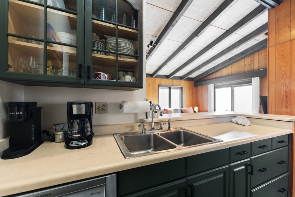 Cook your favorite meals in this fully equipped kitchen with exposed beams, glass-front cabinets, and modern appliances.