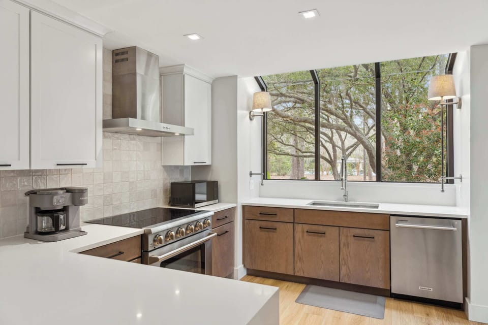The sleek, airy kitchen offers ample space & every home comfort