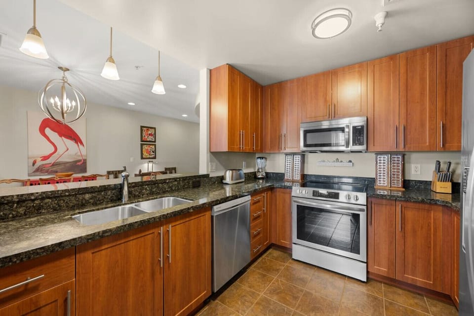 The modern kitchen features a bar counter, complete with all utensils and appliances, perfect for preparing meals or enjoying a casual snack while staying connected with friends and family.