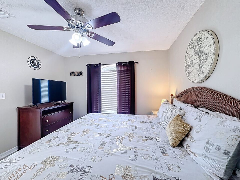 Elegant master bedroom with a plush bed, flat-screen TV, and warm decor for ultimate comfort.