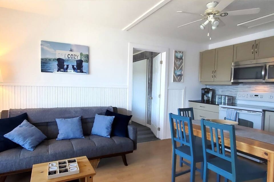 Living room with kitchen to right and pull-out couch for additional sleeping space