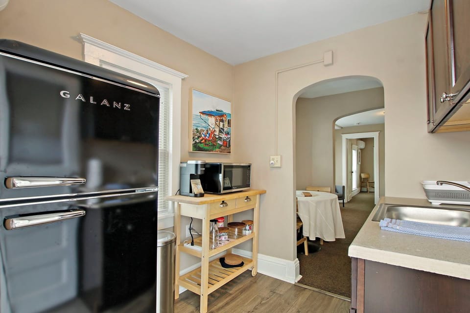 Kitchenette with fridge, microwave, sink, coffee station. No stove