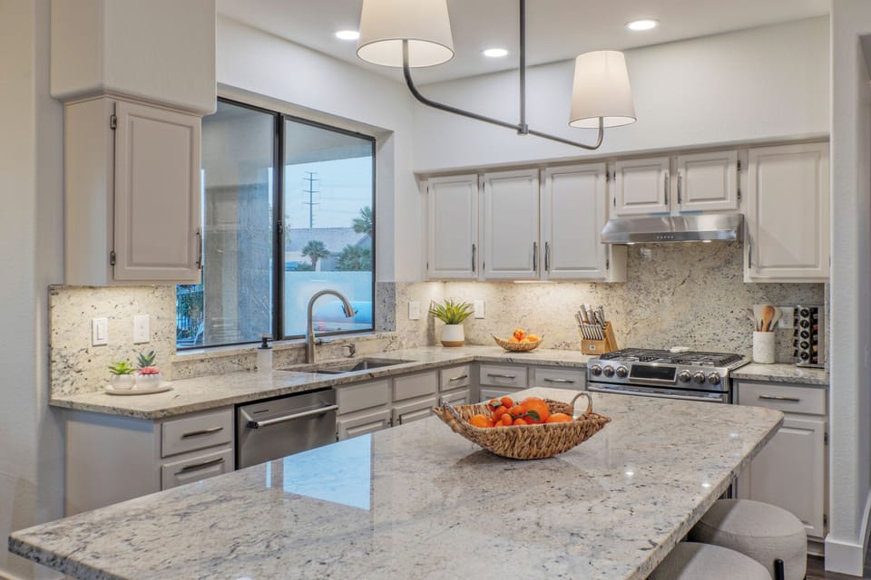 Modern kitchen has beautiful counters for serving eats and treats.