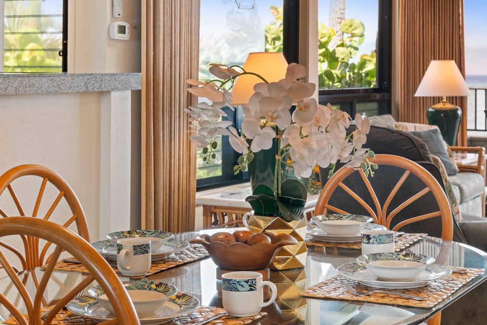 Elegant dining area with glass‑top table, tropical themed décor, and bright natural light that enhances every mealtime.