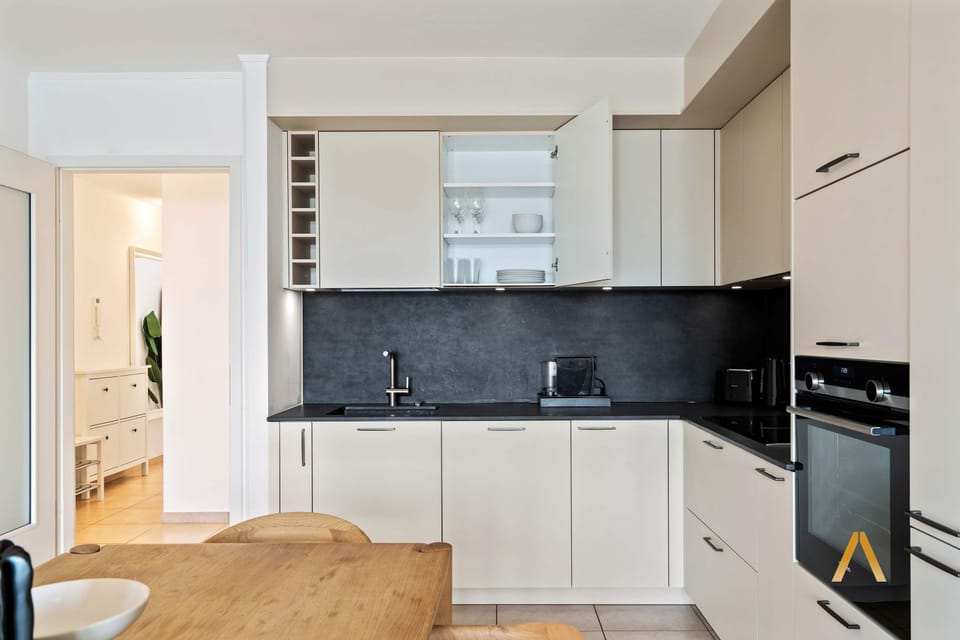 Modern kitchen with sleek cabinetry and ample storage. Equipped with all essentials for cooking, providing a seamless culinary experience.