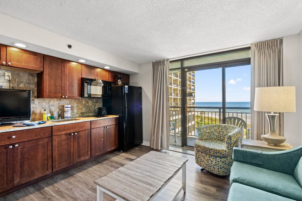 Bright & Beachy Living Room, Stocked Kitchen. Enjoy a sunlit living space with a cozy beach-themed décor, Smart TV, and plush couch for relaxation. The fully stocked kitchen features a refrigerator & microwave, perfect for easy meals. Coastal vibes!