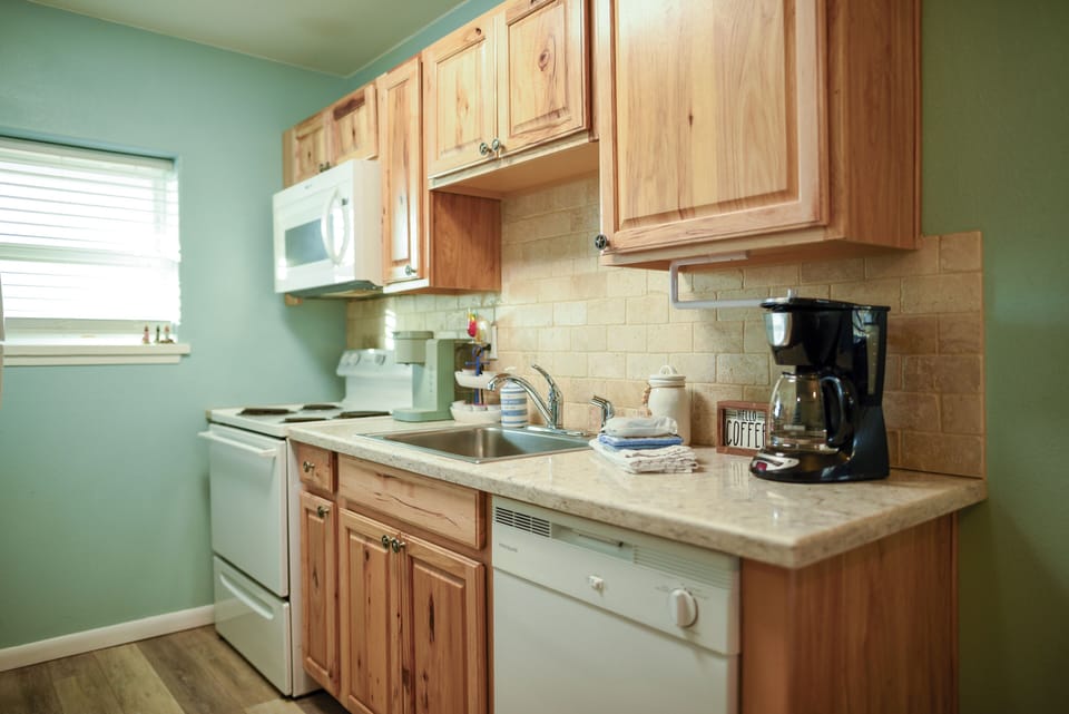 Your fully equipped kitchen awaits with warm wood cabinets, modern appliances, and everything you need to create memorable meals during your stay.