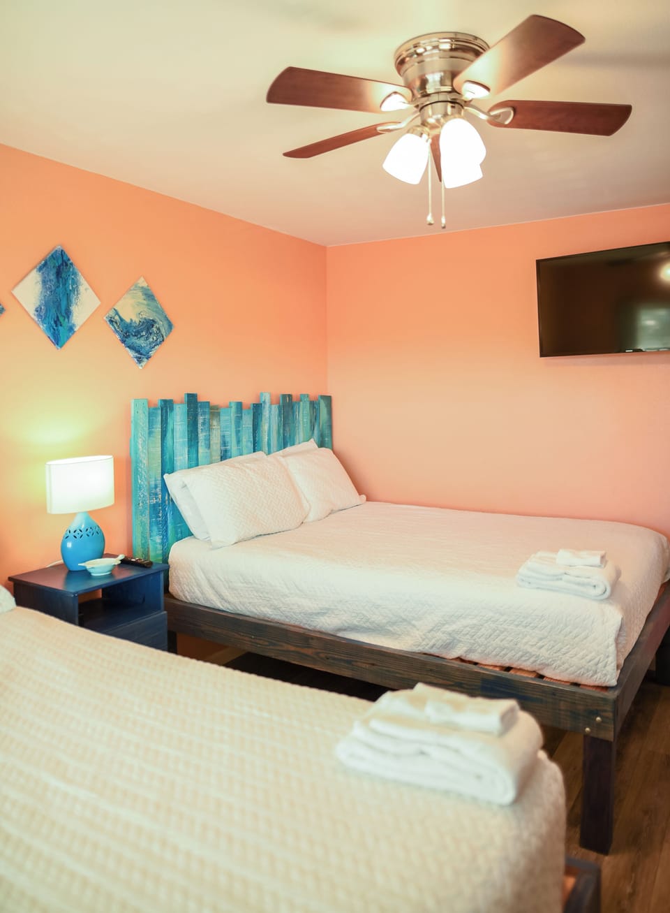 Relax in your coastal-themed bedroom with ocean-blue accents, ceiling fan, and flat-screen TV for ultimate comfort.
